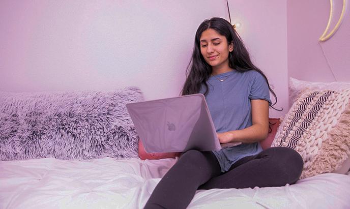 Student sitting using a laptop