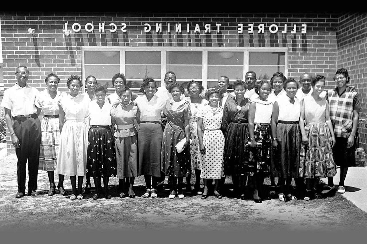 Image: The 21 teachers who lost their positions for their refusal to comply with the anti-NAACP oath standing in front of the  Elloree Training School in Elloree, South Carolina, on May 15, 1956. This photograph appeared in Jet magazine on June 7, 1956.  (Image courtesy of photographer Cecil Williams, Cecil Williams Civil Rights Museum, Orangeburg, South Carolina.)